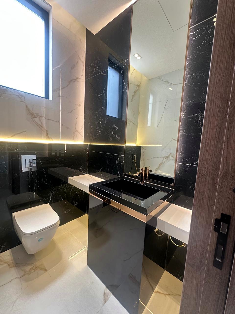 Modern black vanity with warm linear lighting